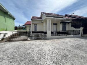 a house with a fence in front of it at D' Mande Homestay Bukittinggi in Bukittinggi