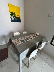 a dining room table with chairs and a quilt on it at D' Mande Homestay Bukittinggi in Bukittinggi +6 photos