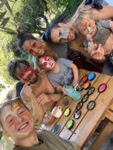Un grupo de personas con caras pintadas de pie alrededor de una mesa de picnic. en Private bedroom with bathroom, en San Rafael