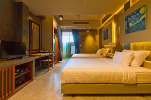 a hotel room with two beds and a flat screen tv at Kroque Boutique & Bistro in Ang Sila