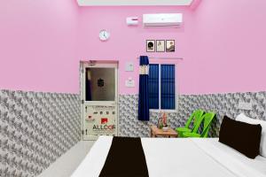 a room with a bed and a pink wall at OYO Flagship Hotel O Mo Kudia in Puri +34 photos