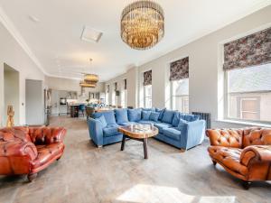 a living room with blue couches and a table at The Embassy in Eyemouth