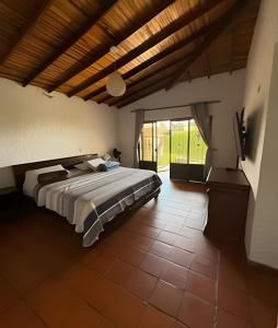 a bedroom with a large bed with a wooden ceiling at Exclusiva cabaña el lago- Naturaleza in Chinácota +57 photos