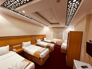 a hotel room with three beds in a room at Ghazala Beautiful Hotel shuttle service to the Haram in Mecca +58 photos