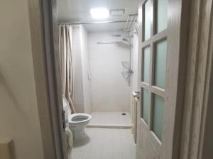 a white bathroom with a toilet and a shower at egolife in Beijing