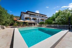 una piscina frente a una casa en Apartments Villa Verica - Mit Meerblick & Pool auf der Insel Rab, en Banjol