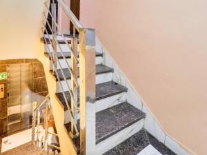 una scala in una casa con ringhiera di metallo di Hotel O Sharda a Gwalior