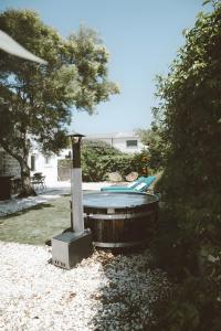 - un bain à remous dans une cour avec un arbre dans l'établissement Carignan - Gîtes Du Mas Des Jeux, à Saint-Laurent-dʼAigouze