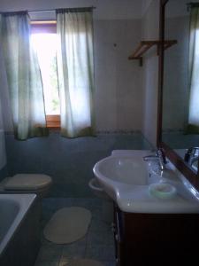 uma casa de banho com um lavatório, um WC e uma janela. em Casa Moron em Saint-Vincent