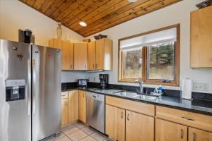 a kitchen with stainless steel appliances and wooden cabinets at Mountain Dream in Stowe