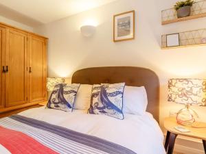 une chambre avec un lit avec des oreillers bleus et blancs dans l'établissement 2 Bed in Downderry 89885, à Downderry