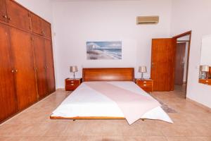 a bedroom with a large bed with wooden furniture at Carpe Diem in Faro +24 photos