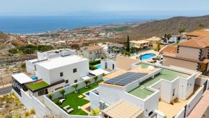 an aerial view of a house with solar panels on the roof at Saras Village in Adeje