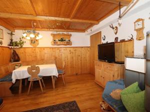 a dining room with a table and a tv at Pargger in Hippach