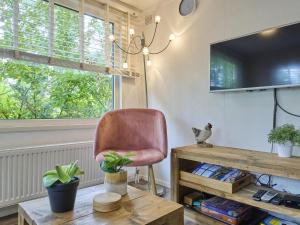 GortelにあるDe Havikの椅子、テーブル、テレビが備わる客室です。