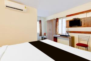 Una habitación de hotel con una cama y un televisor. en Super Townhouse Sankaramatam Road Near Diamond Park, en Visakhapatnam