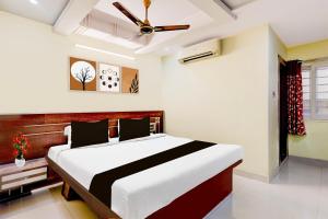 Un dormitorio con una cama grande con ventilador de techo. en Super Townhouse Sankaramatam Road Near Diamond Park, en Visakhapatnam