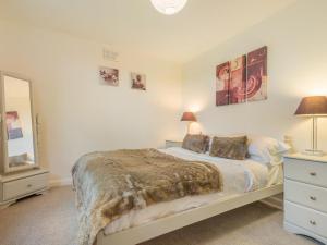 a bedroom with a bed and a dresser and a mirror at 2 Bed in Wasdale SZ077 in Santon Bridge