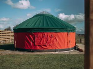 Una carpa verde y roja en el césped. en Moss Yurt - Uk47888, en Keilour 6 fotos más