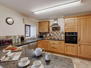 una grande cucina con armadi in legno e piano di lavoro di 3 Bed in Woolsery 05171 a Woolfardisworthy