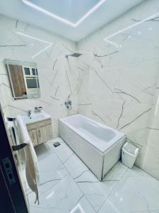 a white bathroom with a tub and a sink at Atta pyramid view inn in Cairo +16 photos