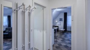 a hallway with white doors and a living room at Kassel - Gemütliches DG Apartment in Fuldatal mit Parkplatz & Wlan - OneN8 in Fuldatal