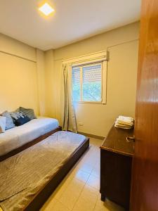 a small bedroom with a bed and a window at Departamento luminoso Bulnes 3 dormitorios in San Miguel de Tucumán