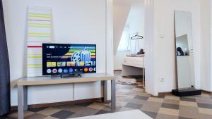 a television sitting on a table in a room at Kassel - Gemütliches DG Apartment in Fuldatal mit Parkplatz & Wlan - OneN8 in Fuldatal +6 photos