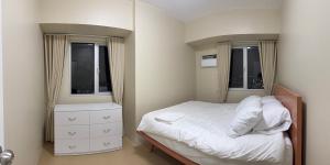 a small bedroom with a bed and two windows at Amayara Nest Hospitality 2BR Condo with Netflix in Cagayan de Oro +21 photos