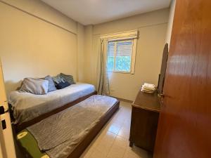 a small bedroom with a bed and a window at Departamento luminoso Bulnes 3 dormitorios in San Miguel de Tucumán