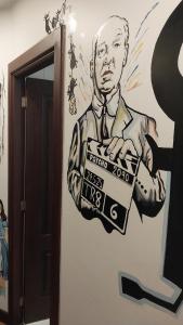 a painting of a man holding a box on a wall at Movie Escape in La Paz