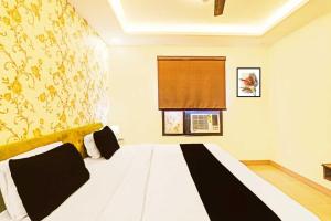 a bedroom with a white bed with a window at Townhouse Oak Kaal Bhairav Temple in Varanasi