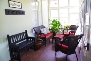 a room with chairs and a table and windows at Colborne Bed and Breakfast in Goderich