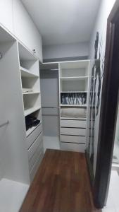 a walk in closet with white cabinets and wood floors at Movie Escape in La Paz