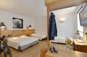 a bedroom with two beds and a desk with a bike at Albergo Les Dependances in Norcia
