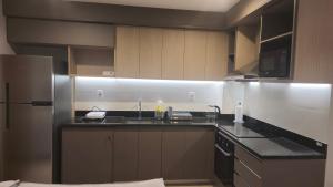 a kitchen with a sink and a refrigerator at Departamento a estrenar en Mburucuya in Asuncion
