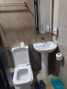 ein Badezimmer mit einer weißen Toilette und einem Waschbecken in der Unterkunft Breeze Homes in Nairobi