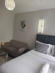 ein Schlafzimmer mit einem Bett und einer Couch in der Unterkunft Breeze Homes in Nairobi