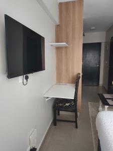 ein Zimmer mit einem Schreibtisch und einem Fernseher an der Wand in der Unterkunft Breeze Homes in Nairobi