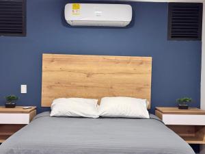 a bedroom with a bed with a blue wall at Laureles Loft con terraza privada cerca Parques Del Río in Medellín +32 photos
