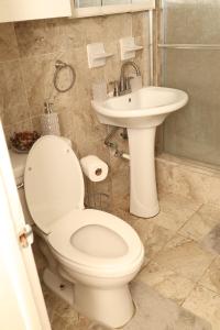 a bathroom with a toilet and a sink at Simplicity1 in North Miami Beach