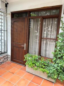 a wooden door with plants in front of a house at Nat!va 301 in Cali