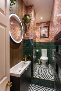 een badkamer met een wastafel, een toilet en een spiegel bij Centre Meadowside Residence in Edinburgh