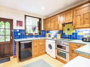 a kitchen with wooden cabinets and a dishwasher at 3 Bed in Northrepps 88327 in Northrepps +12 photos