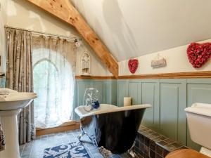 a bathroom with a black tub and a sink at 4 Bed in Latchley 77480 in Sydenham Damerel +60 photos