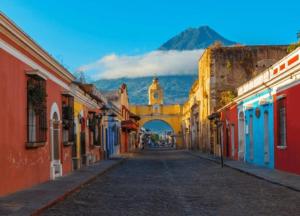 an empty street with a clock tower in the distance at Casa Feliz Antigua in Antigua Guatemala