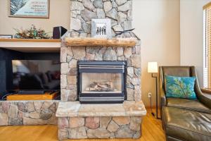 a stone fireplace in a living room with a couch at Timber Heights Lodge in Breckenridge