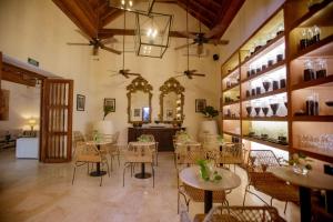 a restaurant with tables and chairs in a room at Palmas de Alba Hotel Boutique in Cartagena de Indias