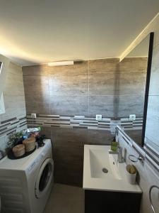 a bathroom with a washing machine and a sink at Casa de Kalika in Chania +5 photos