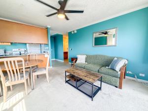 a living room with a couch and a table at Royal Kuhio 1812 - 1BR with partial ocean view in the Heart of Waikiki with Free Parking! in Honolulu